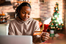 Young woman online shopping from a laptop at home during the Christmas holidays