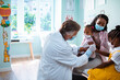 © Marko Geber - Senior pediatrician preparing a young girl for a shot in the clinic