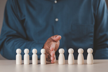 A businessman's hand divides the wooden figure into two sides, a man and a woman. Concept of gender equality teamwork, unity, gender division. Wooden puppet.