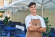 © Krakenimages.com - Young hispanic man waiter smiling confident standing with arms crossed gesture at coffee shop terrace