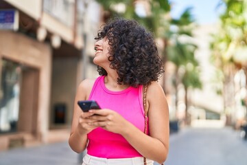 Poster - Young middle eastern woman smiling confident using smartphone at street