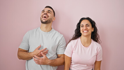 Poster - Man and woman couple laughing a lot standing together over isolated pink background