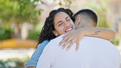 Poster - Man and woman couple smiling confident hugging each other at park