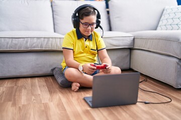 Sticker - Adorable hispanic boy playing video game sitting on floor at home