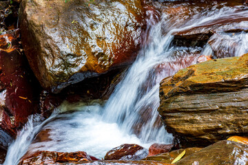 Wall Mural - Movement of river water flowing between rocks in the rainforest in Minas Gerais, Brazil