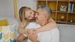 © Krakenimages.com - Man and woman couple hugging each other sitting on sofa at home
