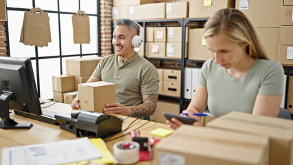 Canvas Print - Man and woman ecommerce business worker having video call holding package working at office