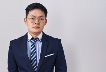 Sticker - Young asian man wearing business suit and tie relaxed with serious expression on face. simple and natural looking at the camera.