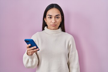 Poster - Young south asian woman using smartphone thinking attitude and sober expression looking self confident