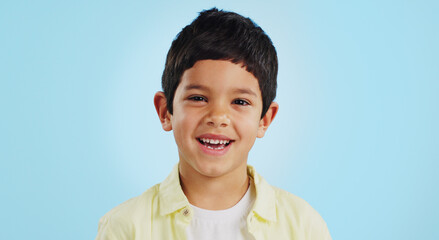 Canvas Print - Face, boy child and smile in studio for wellness and confidence on a blue background with positive mindset. Portrait, kid and happiness with casual fashion, joyful and relaxed expression on mockup