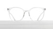 © New Africa - Stylish glasses with transparent frame on wooden table against white background