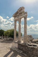 Wall Mural - The ruined Temple of Trajan in Pergamon Ancient City. Corinthian order stone-cut relief on the frieze. Dramatic sky at background. History, art or architecture concept. Bergama, Turkey