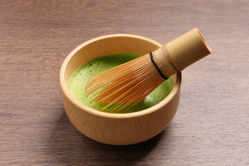 Canvas Print - Cup of matcha tea and bamboo whisk on wooden table