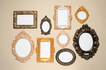 Empty vintage frames hanging on beige wall