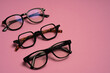 Collection of Three Black Eyeglasses Diverse Shapes on a Pink Background