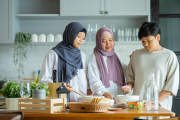 Wall Mural - Cute Girl and Son and Her Muslim Mom In Hijab Preparing Pastry For Cookies In Kitchen, Baking Together At Home. Islamic Lady With Daughter and son Enjoying Doing Homemade Pastry