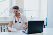 © qunica.com - Experienced doctor analyzing medical results for patients in clinic.