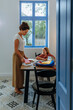 © bernardbodo - Mother preparing her daughter for school during breakfast