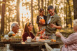 © bernardbodo - Family having a picnic in the forest in fall
