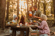 © bernardbodo - Family having a picnic in the forest in fall