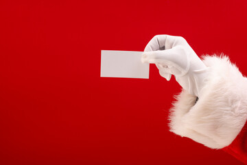 Poster - Santa claus holding white card with copy space on red background