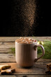 Vertical image of chocolate pouring over mug of chocolate and christmas decorations with copy space