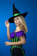 © yevgeniya131988 - Blonde woman in black witch hat wearing costume for Halloween