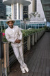 © Anton - An attractive groom at an international wedding in a light suit with dark skin against the backdrop of the modern city of Singapore. His confident posture gives the impression of a strong individual.