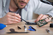 man is repairing broken pc with a screw driver