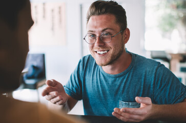 Happy young businessman having meeting with colleague in cafe