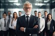 © photolas - Elderly man business boss standing befor office workers in a team portrait representing success and human resources.