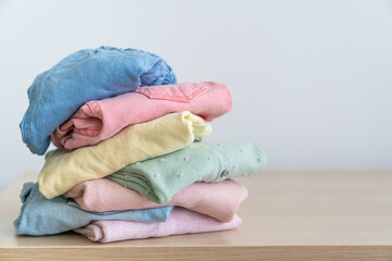 Wall Mural - Stack of clean freshly laundered, neatly folded women's clothes on wooden table