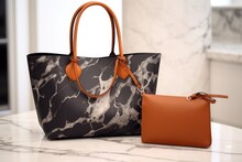 An Imitation Leather Bag Beside A Designer Handbag On A Marble Counter