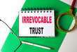 IRREVOCABLE TRUST text on notebook on green paper