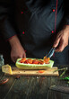 © Віталій Б. - Experienced chef adds a tomato to the zucchini. The concept of cooking a national stuffed squash boat or marrow in a restaurant kitchen.