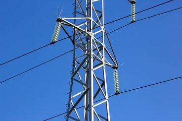 Wall Mural - Electrical tower with voltage transmission wires against the background of blue sky. High voltage tower. power line support with wires for electricity transmission. Energy industry.