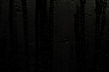 Wet Window With Water Streaks. Glass With Raindrops On A Dark Background. Background Or Overlay For Use In Design.