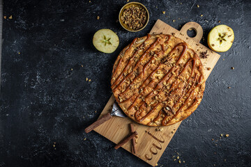 Wall Mural - Homemade Organic Apple Pie with caramel and nuts Dessert on a dark background. top view. place for text