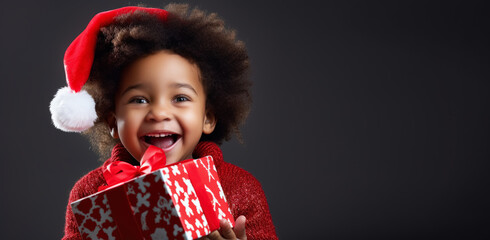 Small cute afro american child with christmas hat holding a present gift. Christmas holiday concept.