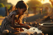 Little African girl keeping hands cupped while washing them in water outdoors