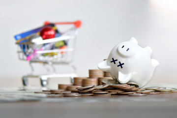 The dead piggy bank lies upside down on coins, Economic crisis, Decrease, layoff, job fired, pay cuts, low cost, collection