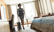 © BalanceFormCreative - African-American businesswoman checking out from the hotel room after all day discussing and talking at the conventions and seminars.