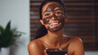 Beautiful young woman applying chocolate mask on her face at home.