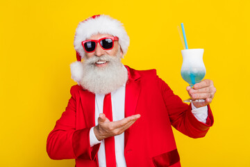 Poster - Photo of cheerful cool senior guy wear x-mas suit recommending enjoying tasty beverage isolated yellow color background