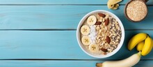 Healthy Protein Rich Breakfast With Overnight Oats Banana Pecans Chia Seeds Arranged Around In A Top View Shot On A Blue Wooden Table With Copyspace For Text