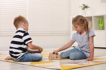 Canvas Print - Little boy and girl playing with set of wooden animals indoors. Children's toys