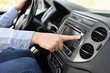 © New Africa - Choosing favorite radio. Woman pressing button on vehicle audio in car, closeup