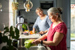 © Marko Geber - Senior lesbian couple washing and preparing a vegetarian dinner in the kitchen at home