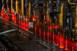 Glass factory, production of glass containers. Molten glass is blown into molds. Robotics in industry. Modern technologies, robotic machines produce products. Technological work at the plant.