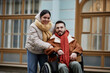 © Seventyfour - Portrait of young couple with disability looking at camera outdoors in city street, copy space